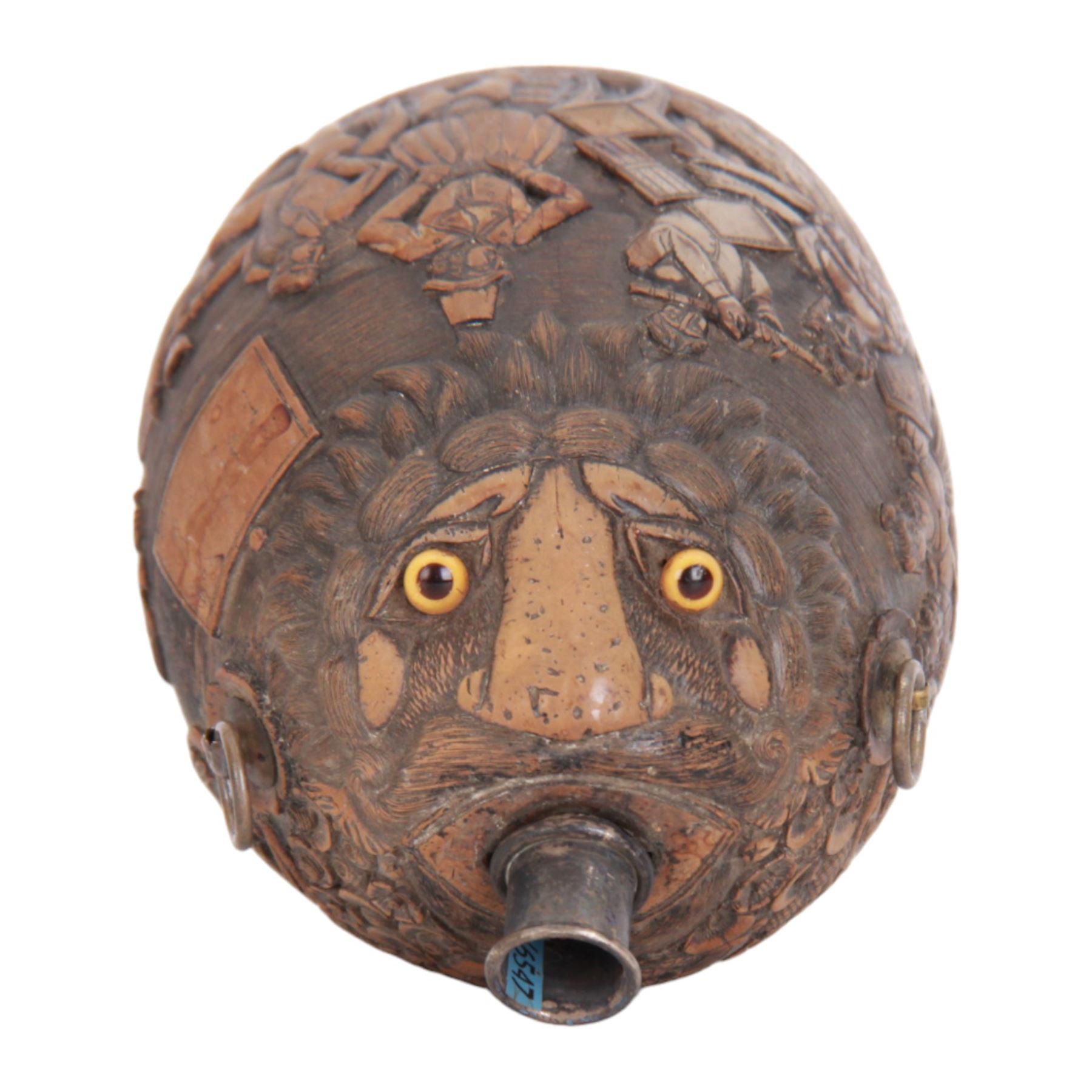 Early 19th century carved coconut 'bugbear' flask, carved with circular panel of Justice stood by a vacant oval shield, holding scales and sword aloft, and stood upon a serpent, and a vignette carved with figures in merriment, drinking and playing music, with profusely carved foliate detail to the rest of the body, the top carved with typical grotesque face with inset glass eyes, and metal nozzle mouthpiece, including mouthpiece L17.5cm 

