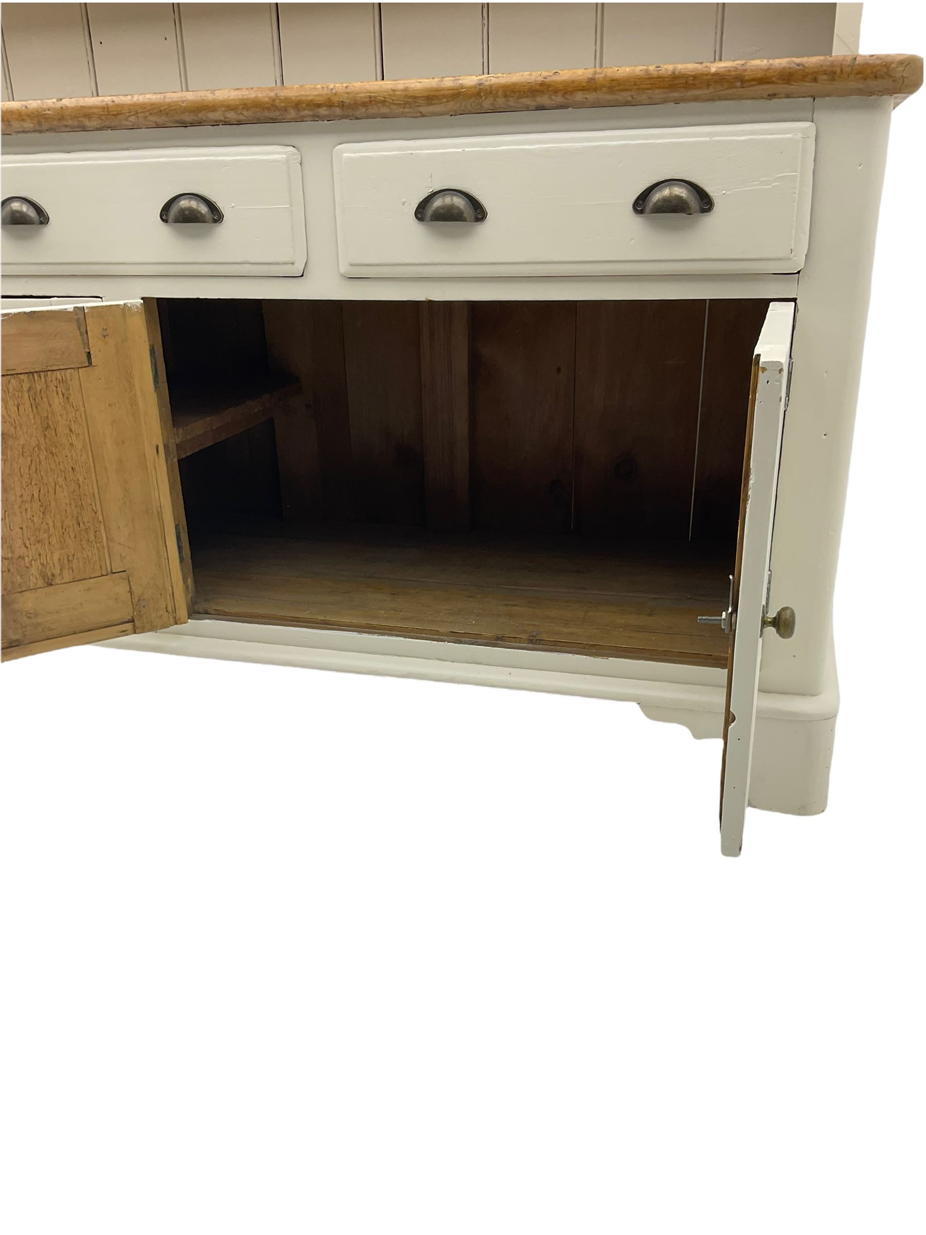 Victorian pine dresser, raised painted three heights plate rack with projecting cornice, waxed top over pained base fitted with three drawers and two double cupboards, bracket feet