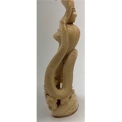 A large Japanese carved ivory okimono, modelled as a figure stood upon one leg with arms outstretched, upon a five headed serpent emerging from waves, H30cm.