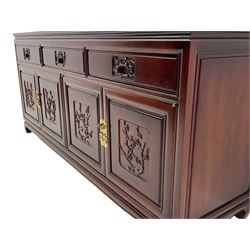 Chinese hardwood sideboard, three drawers above four cupboards, the doors relief carved with flowers and birds 