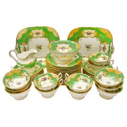 19th century Minton tea set, comprising twelve teacups, eleven saucers, fifteen side plates, cream jug, slop bowl, and two cake plates, decorated with panels of floral sprays, upon a green ground, heightened with gilt throughout, with printed puce mark beneath, and pattern number 5329
