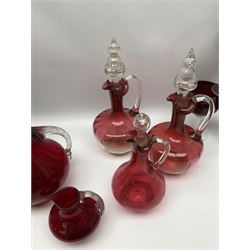 Group of cranberry glass, comprising three ewers with clear glass stoppers and fluted rims, two jugs and a set of six wine glasses