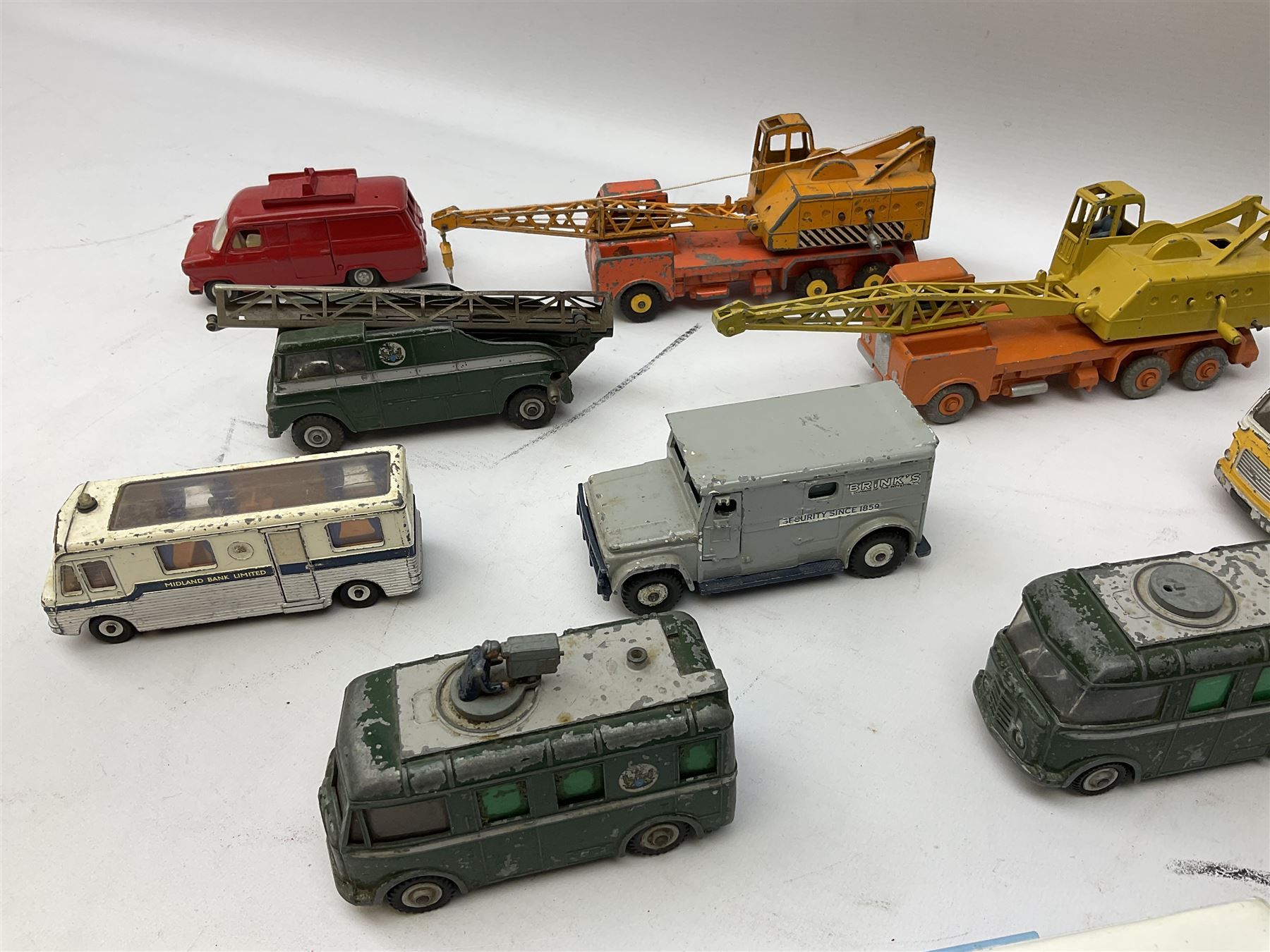 Dinky - thirteen unboxed and playworn die-cast commercial vehicles including two Supertoys 20-Ton Lorry-Mounted Cranes; Leyland Octopus Tanker; Fire Engine No.955; Extending Mast Vehicle No.969; two TV Roving Eye Vans No.968; three Ford Transit Vans; Brinks Armoured Car No.275; etc