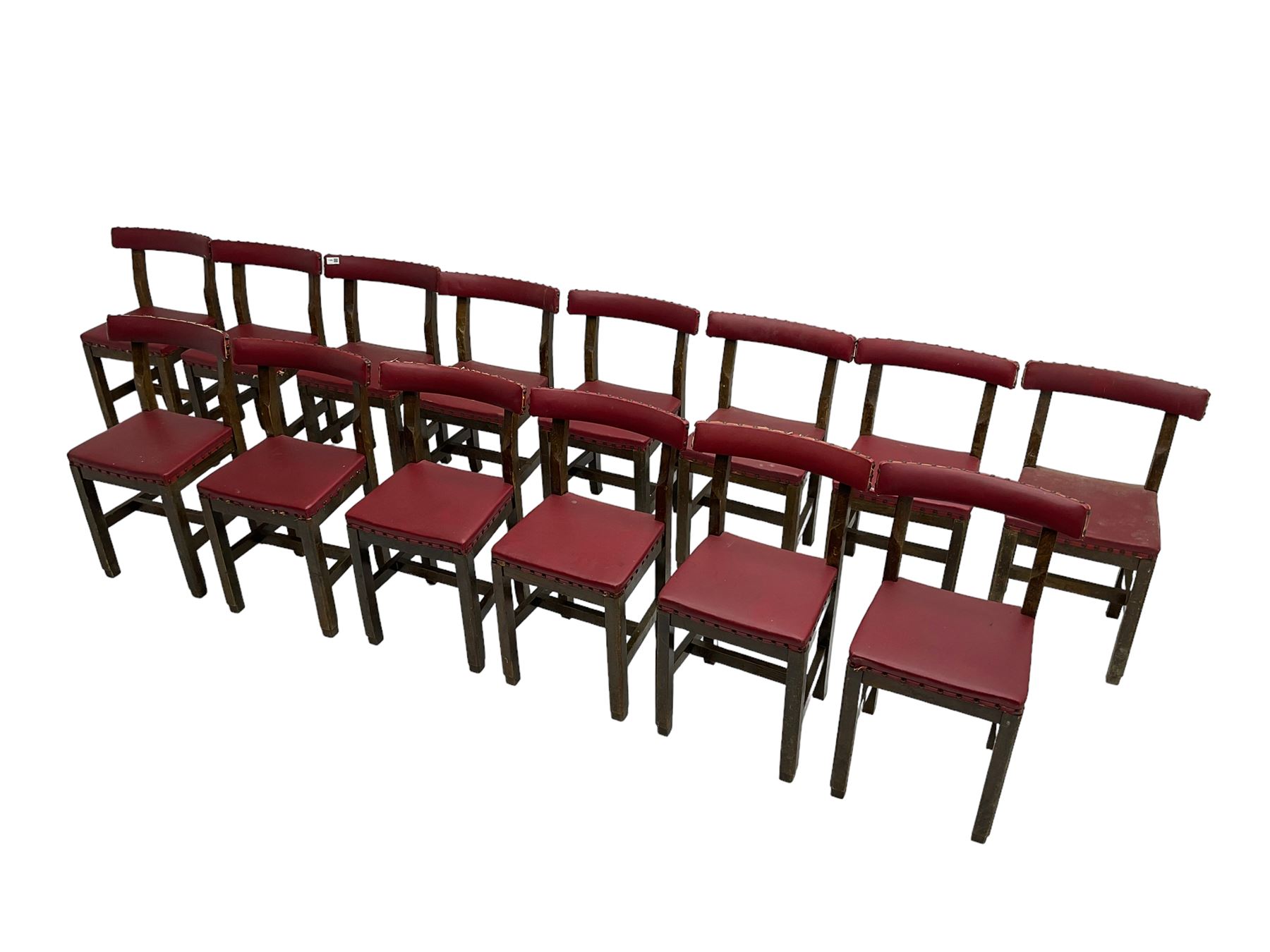 Set fifteen early 20th century oak school chairs, back rail and seat upholstered in claret red faux leather with studwork, raised on square supports united by H-stretcher (15)