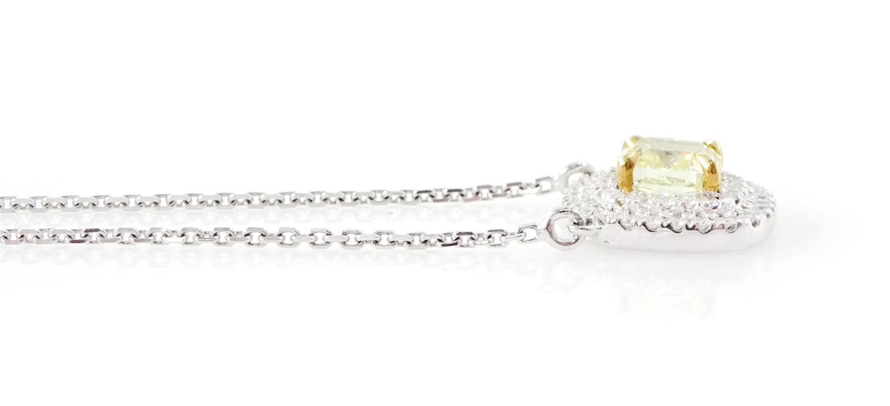 18ct white gold diamond pendant necklace, single cushion cut fancy yellow diamond of 1.05 carat, surrounded by a double halo of round brilliant cut white diamonds, to a fine trace link chain necklace, hallmarked, total white diamond weight 0.26 carat 
