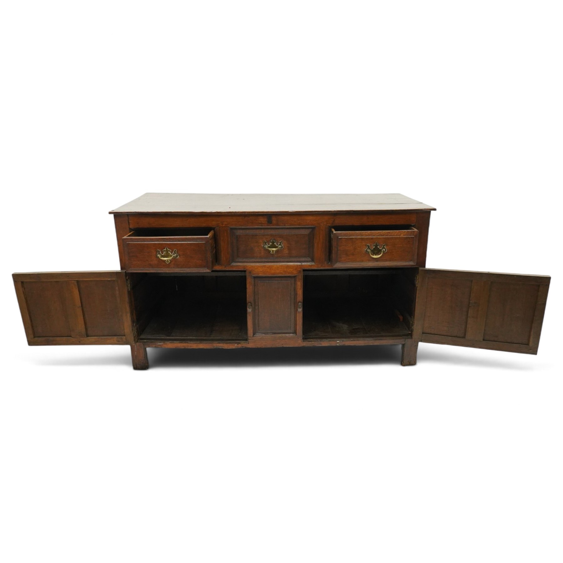 18th century oak dresser base, rectangular top over three drawers, fitted with twin panelled hutch-cupboard doors flanking central fielded panel, raised on stile supports