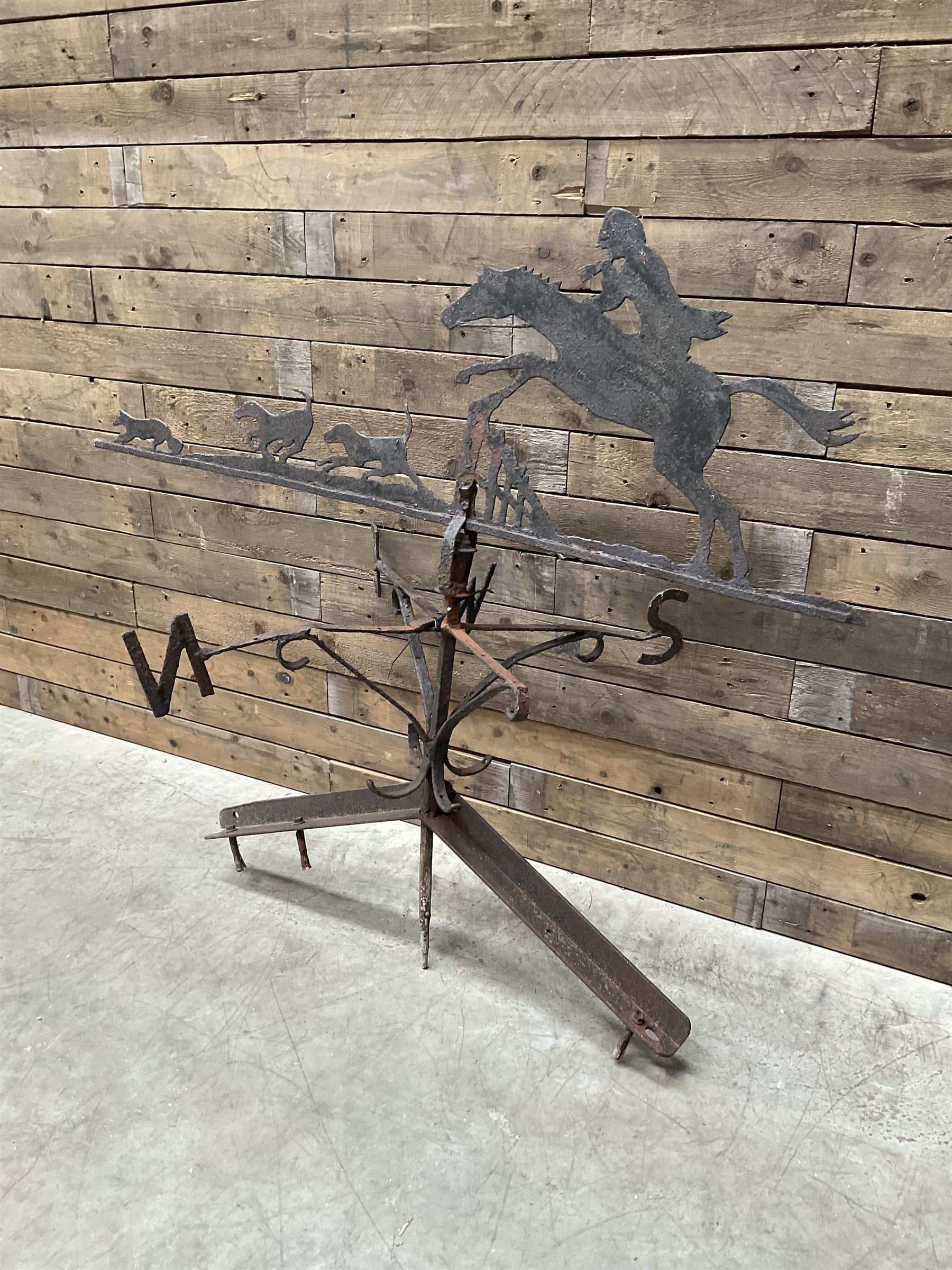 Black painted wrought iron weather-vane depicting hunting scene and compass points