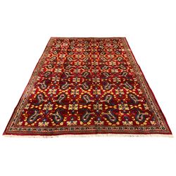 Persian Najafabad red ground rug, the field decorated with Boteh and stylised flower head motifs, narrow floral and geometric design triple band border
