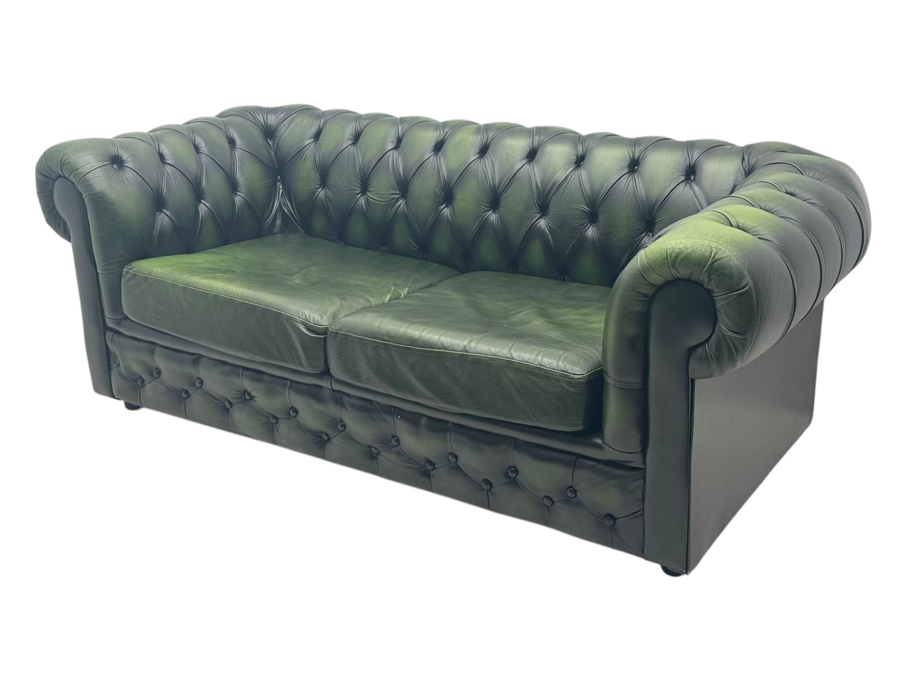 Two seat Chesterfield design sofa bed, upholstered in emerald green leather with deep-buttoned detailing, rolled arms, two loose seat cushions, and pull-out 
