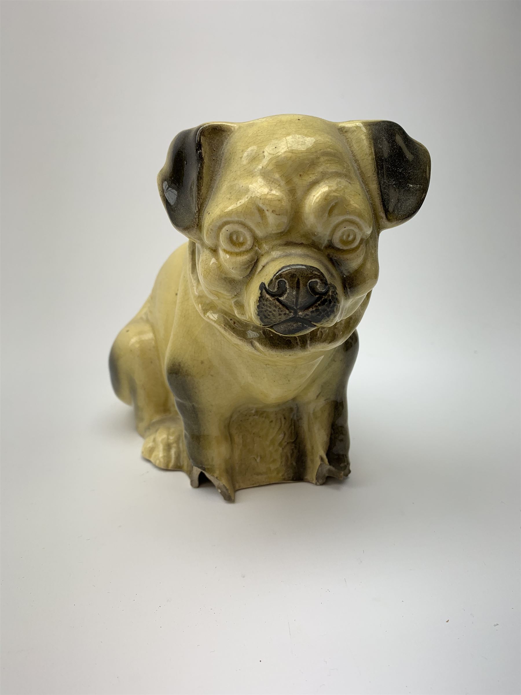 A collection of various ceramic figurines, to include pair of small 19th century Staffordshire cats, Royal Doulton cat, Coalport cat, pair of 19th century pug dogs, two fairings inscribed Good Templars, two Bonzo dog peppers, a number of pin cushion dolls, various 20th century and later black pottery cats, Victorian bisque figures, etc. 