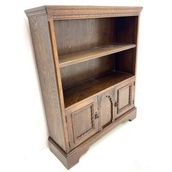 Mid 20th century oak open bookcase, single shelf above two base cupboard, shaped plinth base
