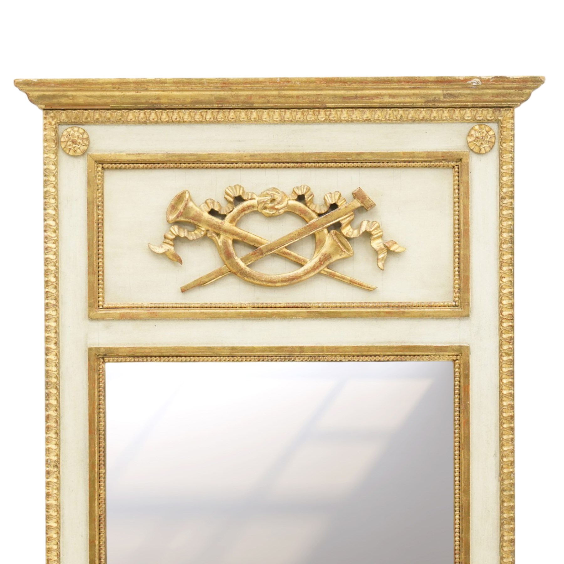 Neoclassical design pair of cream painted and gilt pier mirrors, projecting moulded cornices above frieze panels decorated with ribbon-tied musical trophies, rectangular plates within beaded slips, the outer frames with repeating leaf borders and flowerhead roundels