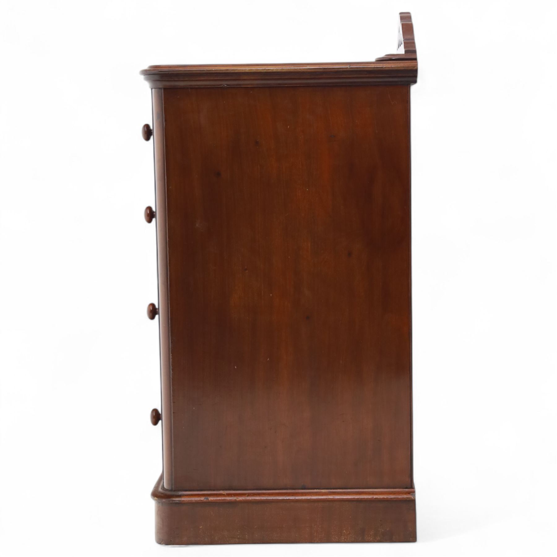 Pair of tall Victorian mahogany bedside chests, of narrow upright form, rectangular top with moulded edge, the back with raised pierced fretwork gallery, above four graduated drawers with knob handles, raised on a plinth base 