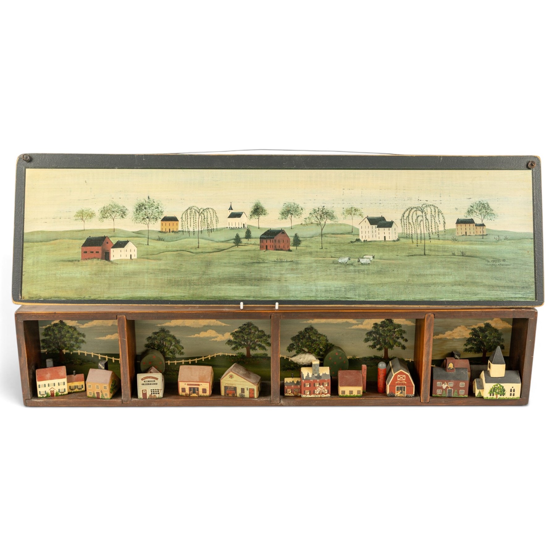 After D Chase (American 20th century): Sunday Afternoon, coloured print 19.5cm x 75.5cm; together with a diorama of an American Midwest Town with naive buildings, within a painted wooden display, houses signed named and dated 1985