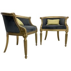 Pair of French design gilt framed tub shaped armchairs, scrolled arm terminal over moulded frieze rail, on reeded supports, upholstered in navy fabric with studwork