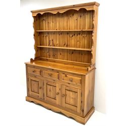 Pine farmhouse dresser with three drawers and three cupboards, and two tier plate rack