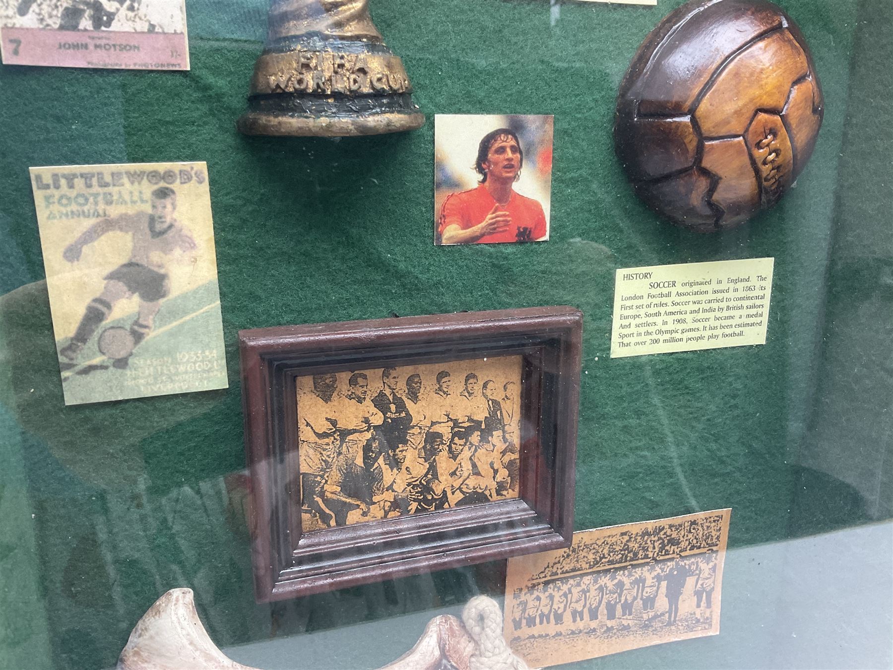 Four framed sporting memorabilia displays, the largest example containing 1930s cricket memorabilia, together with two fishing displays and a football display, each within wooden glazed frames, largest H105cm