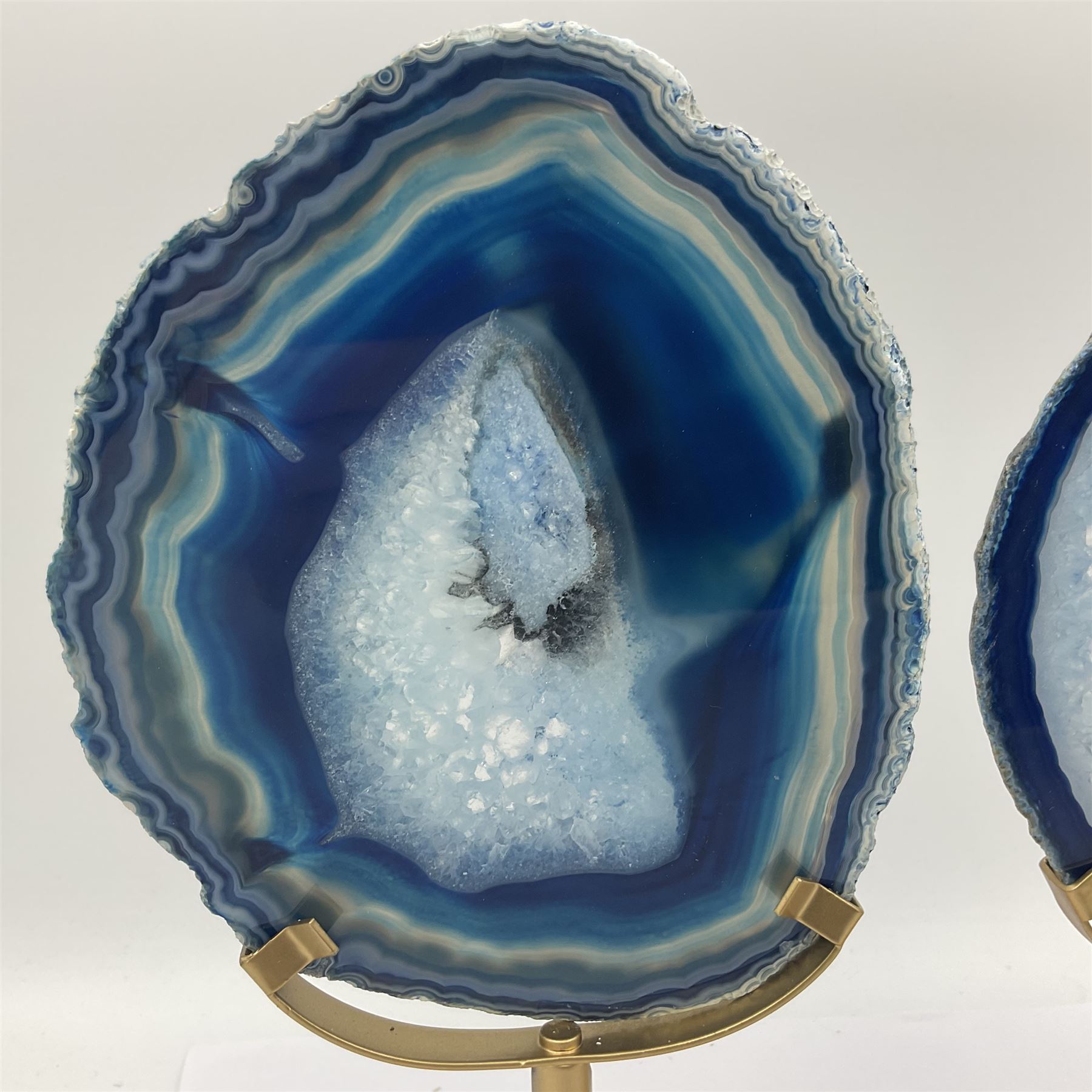Pair of blue agate slices, polished with rough edges raised upon gilt metal stands, H22cm