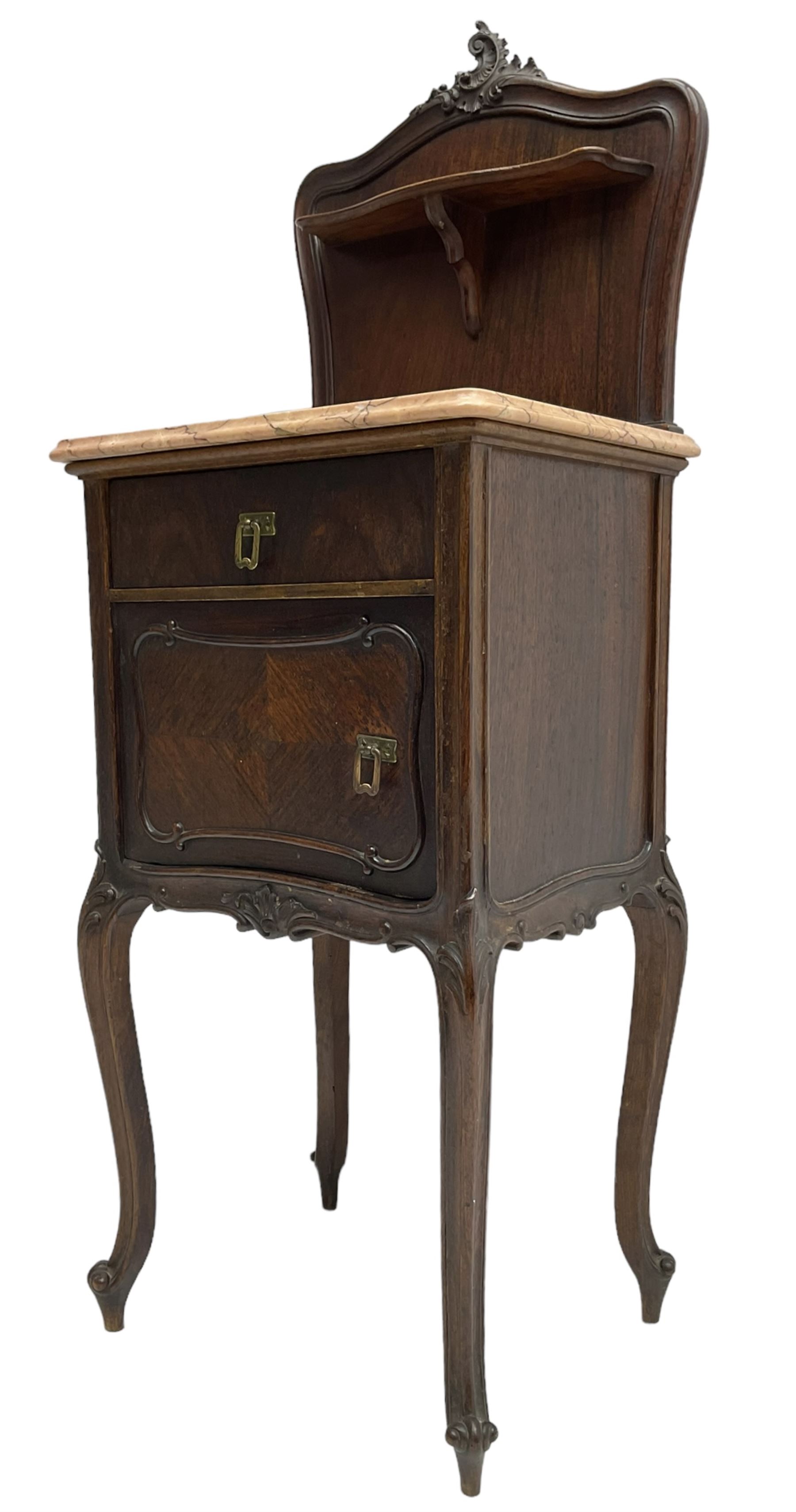 Late 19th to early 20th century walnut bedside pot cupboard, the shaped raised back with carved C-scroll pediment, pink variegated marble top, fitted with single drawer and cupboard, foliage carved cabriole supports with scroll carved terminals