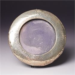 Embossed silver photograph frame London 1985 aperture 12.5cm x 8.5cm, another with scroll top Birmingham 1921 13cm x 9cm and a circular frame Birmingham 1909 6cm