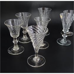 Nine 19th century drinking glasses with wrythen twist and part fluted bowls, comprising a set of three with bell shaped bowls, a near set of three with funnel bowls, a further similar pair, and a single example with drawn trumpet bowl, tallest H11.5cm