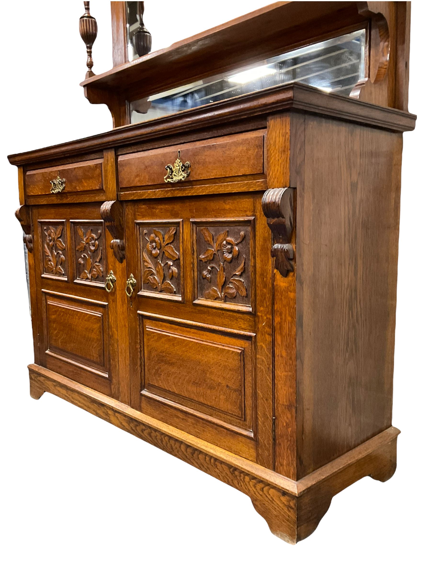 Edwardian oak mirror back sideboard, raised shaped pediment carved with acanthus leaves over Greek key frieze, bevelled mirror back, fitted with two drawers and two cupboards