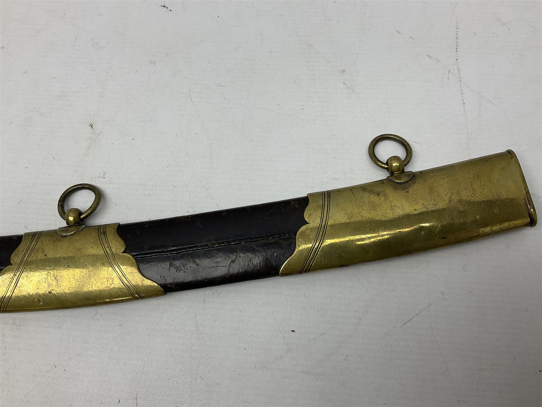 British pattern 1796 Light Cavalry Officer's sword, the 83.5cm curving steel blade marked 'W. Parker London' and 'Warranted' verso, brass stirrup hilt with half-round langets, knucklebow and backstrap with ribbed ivory grip; in brass mounted leather covered scabbard with two suspension rings L97cm overall. This item has been registered for sale under Section 10 of the APHA Ivory Act 