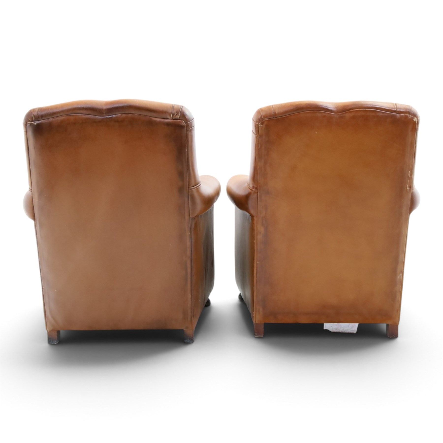 Pair of brown faux leather tub armchairs, scrolled arms with studded detail, turned front feet