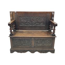 Late 19th century oak monk's bench, the hinged back or top carved with mythical winged dragons, central cartouche and scrolling acanthus leaves, on turned supports, hinged box seat revealing storage, the panelled front matching the back, shaped bracketed skirt carved with shell and scrolled leafage