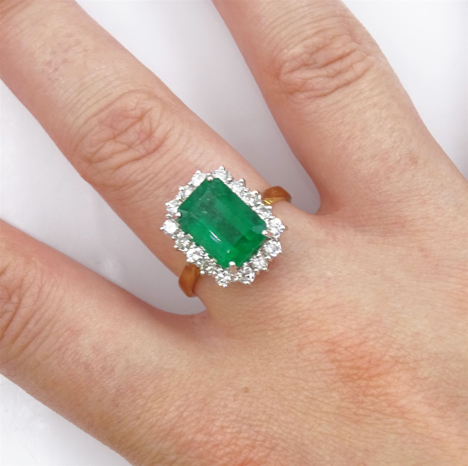 18ct gold emerald and diamond cluster ring, single octagonal cut emerald of approx 3.80 carat, with round brilliant cut diamond surround, hallmarked, total diamond weight approx 0.50 carat