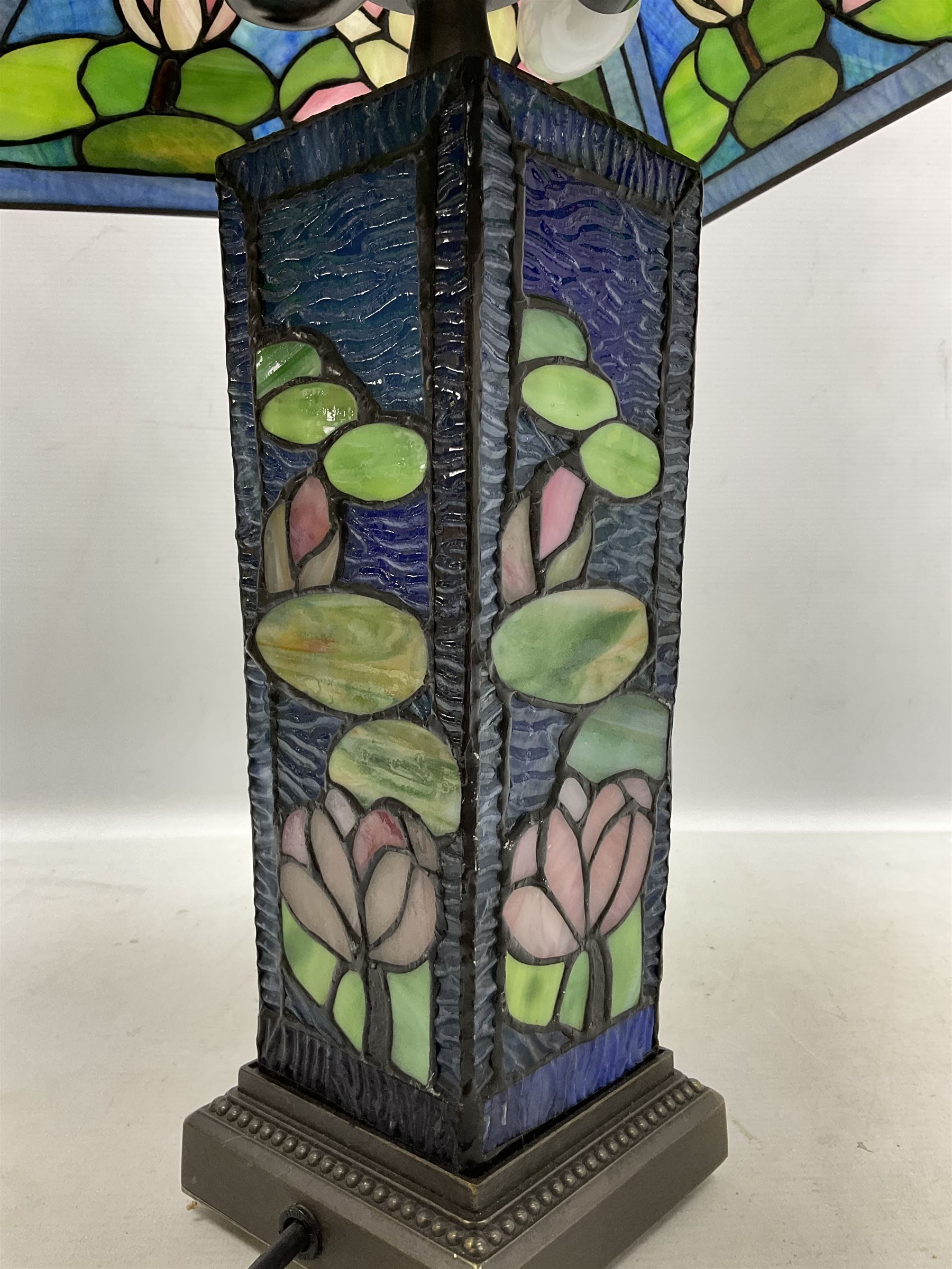 Tiffany Pond Lily style table lamp and shade with leaded panels of green, pink and rippled blue water effect ground, raised upon brushed metal base, H50cm