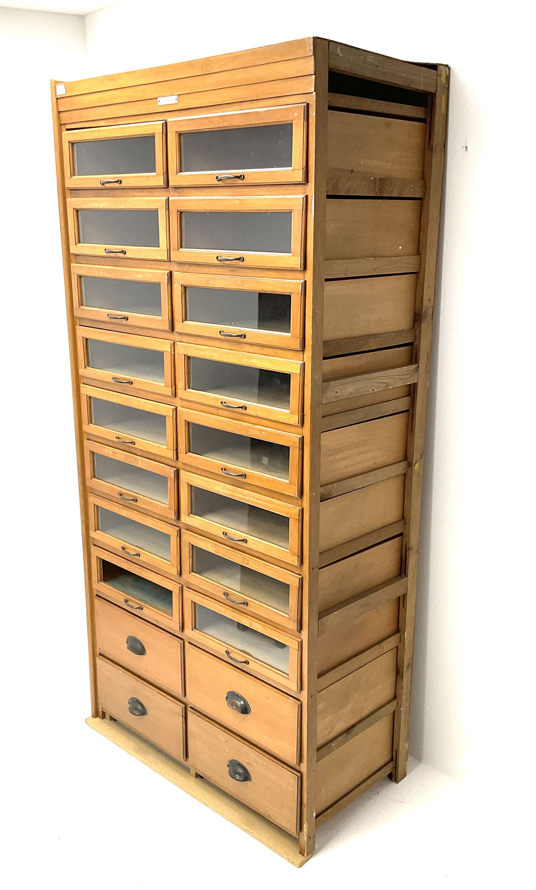 Haberdashery display cabinet with plaque ‘J.C. King Ltd, Shop fittings & Sundries, St John's Street London’, sixteen glazed front short drawers, above four deep drawers