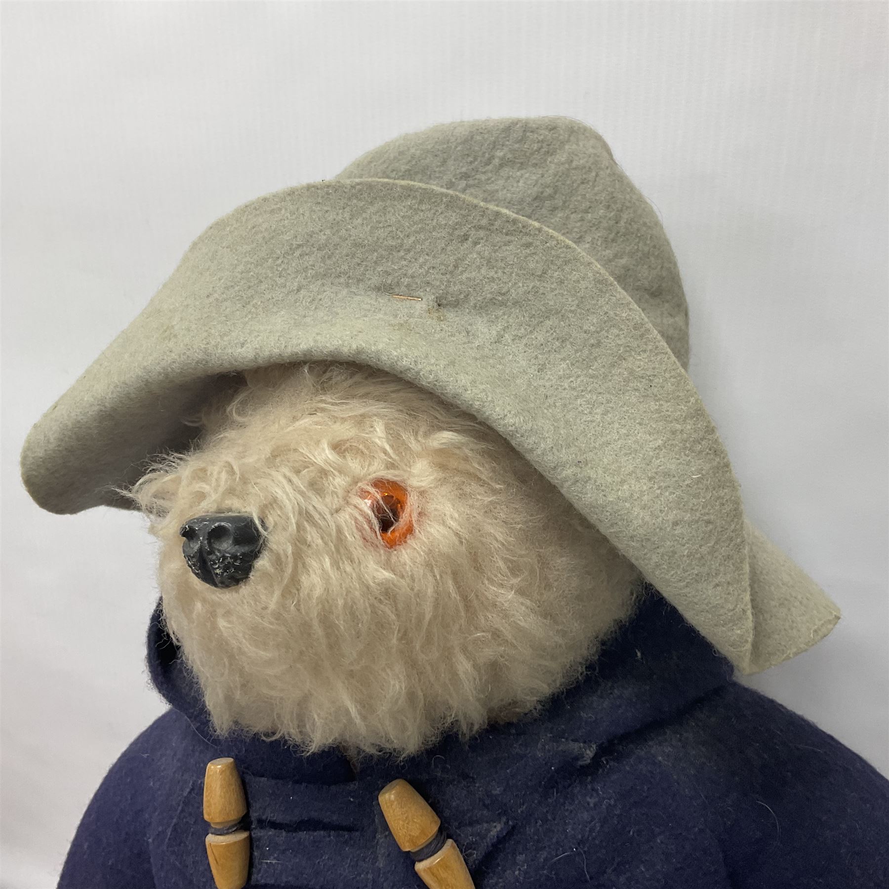 Pair of Paddington Bear teddies with amber eyes, the first example having a brown felt hat, red coat and blue PB boots with original label; the second having a grey felt hat, blue coat and blue Dunlop boots, tallest H51cm 