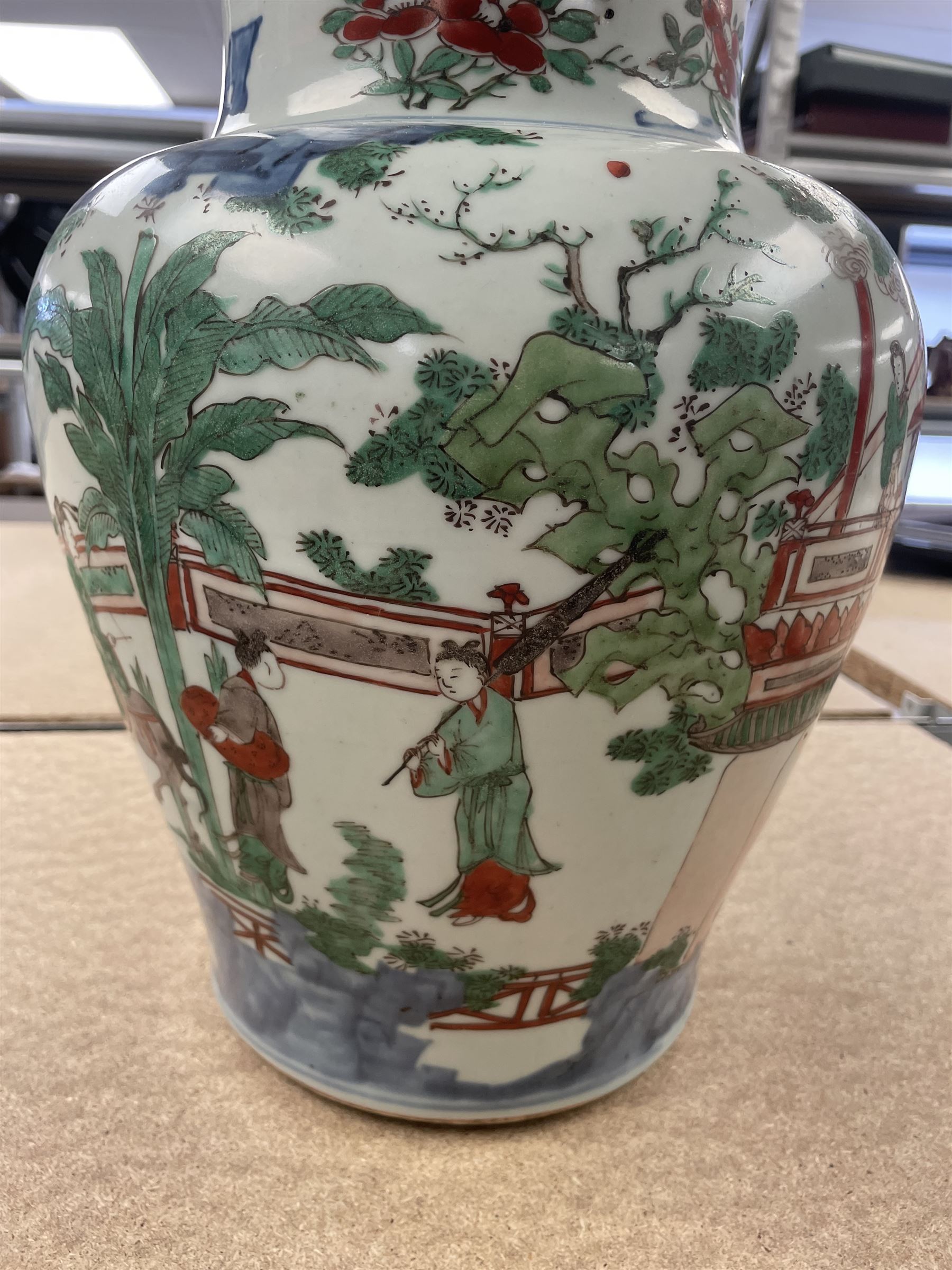17th century Transitional period Chinese Wucai vase and cover, of baluster form, the body painted with ladies upon a terrace, and figures upon horseback and attendants within a fenced garden, the domed cover with knop finial painted with boys at play, H37cm
