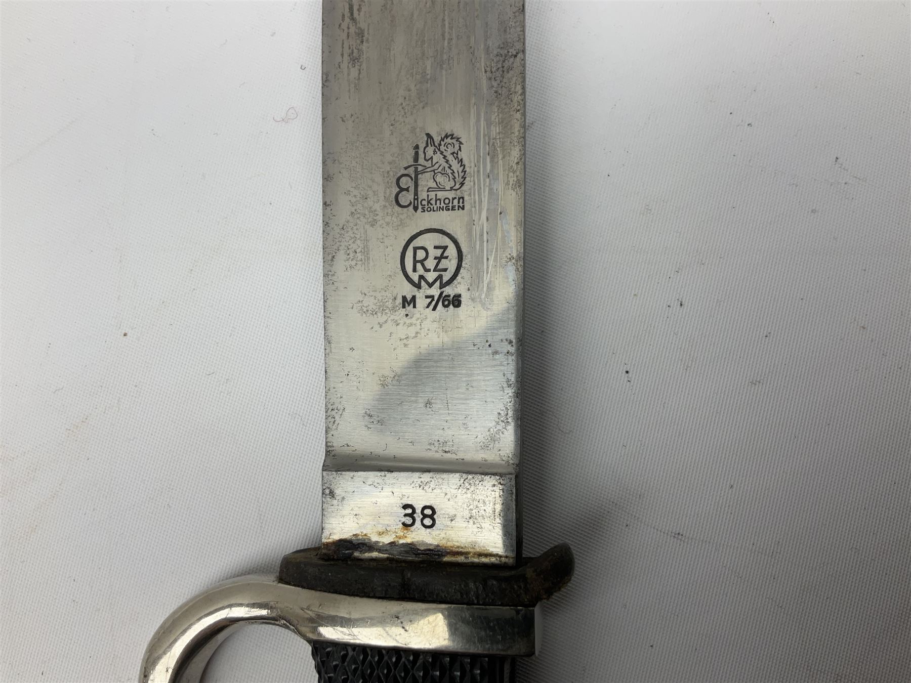 German Hitler Youth dagger the 14cm steel blade by Eickhorn Solingen inscribed Blut und Ehre and marked RZM M 7/66, chequered black grip with inset enamel diamond shaped insignia; in steel scabbard with leather frog L27cm overall