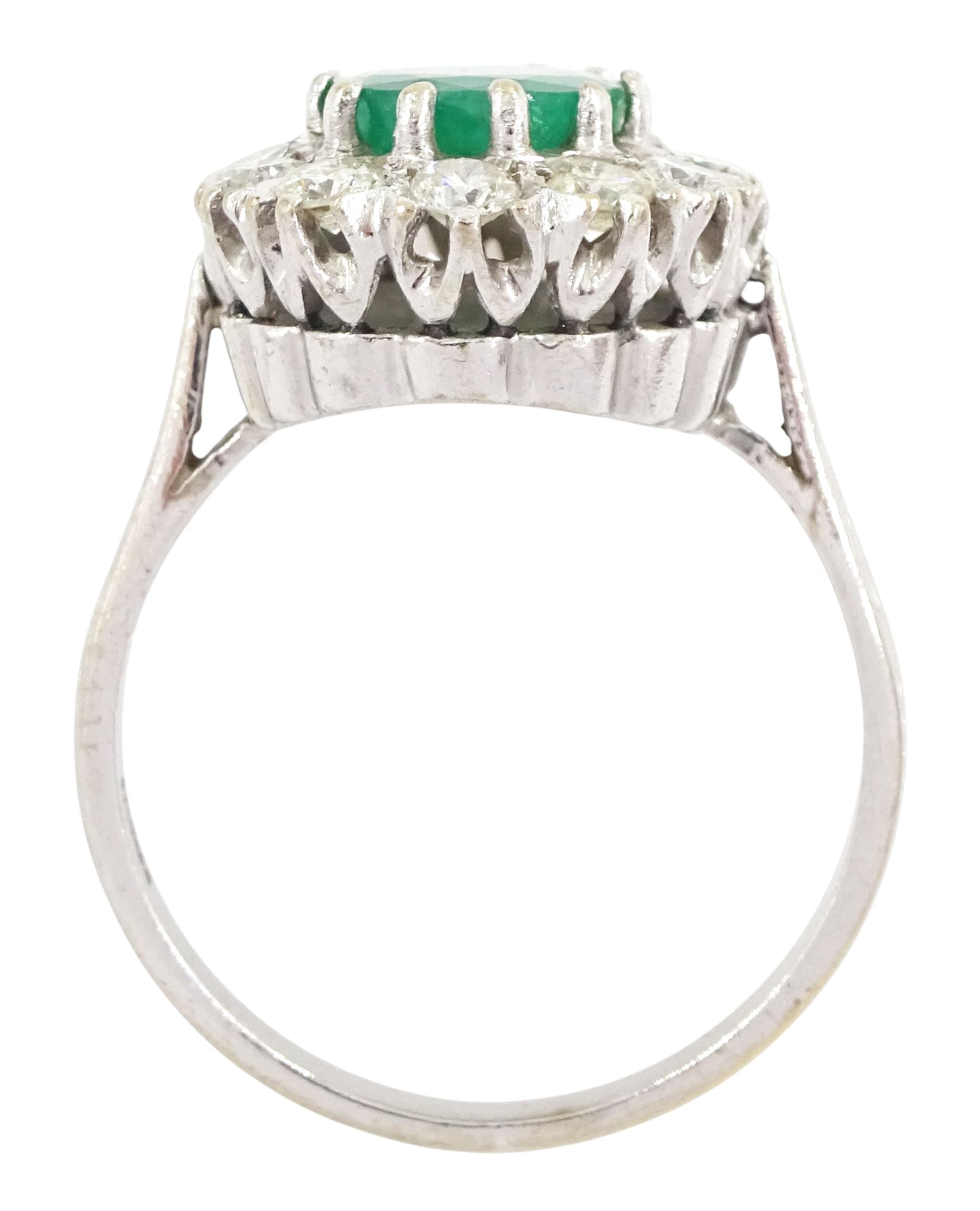 White gold emerald and diamond cluster ring, single oval cut emerald of approx 1.35 carat, surrounded by twelve brilliant cut diamonds, stamped 18ct, total diamond weight approx 0.85 carat