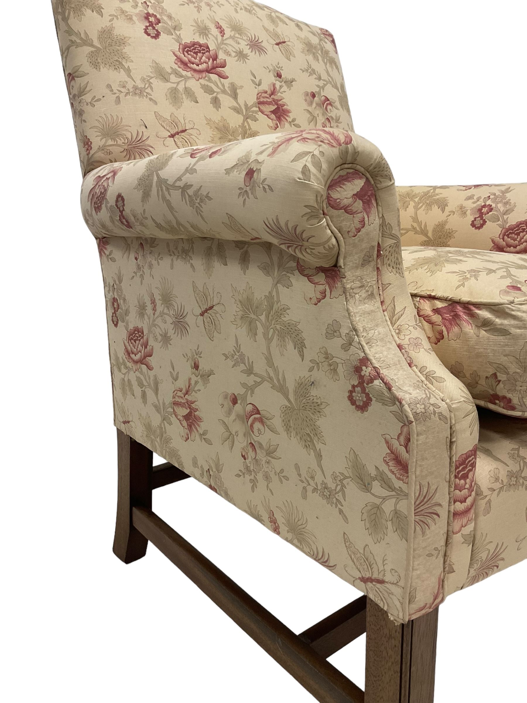 Peter Dudgeon - Georgian design mahogany framed armchair, shaped cresting rail over sprung back and seat flanked by rolled arms, upholstered in floral patterned fabric with matching seat cushion, on square supports joined by stretchers
Provenance: From the Estate of the late Dowager Lady St Oswald