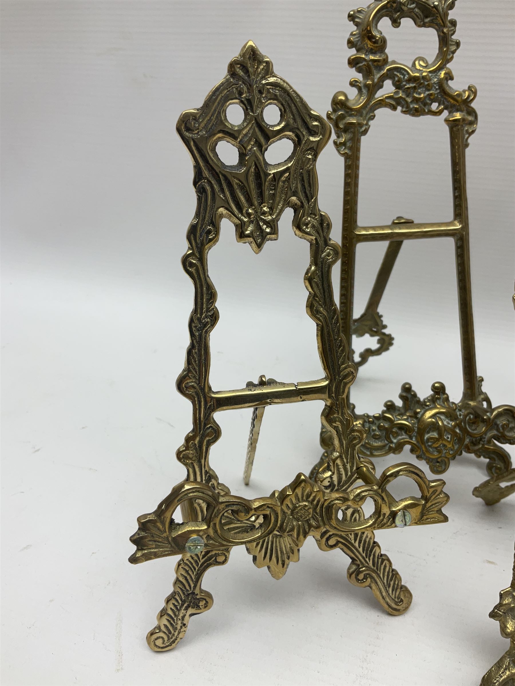 Nine ornate cast brass easel stands of various sizes, H24cm