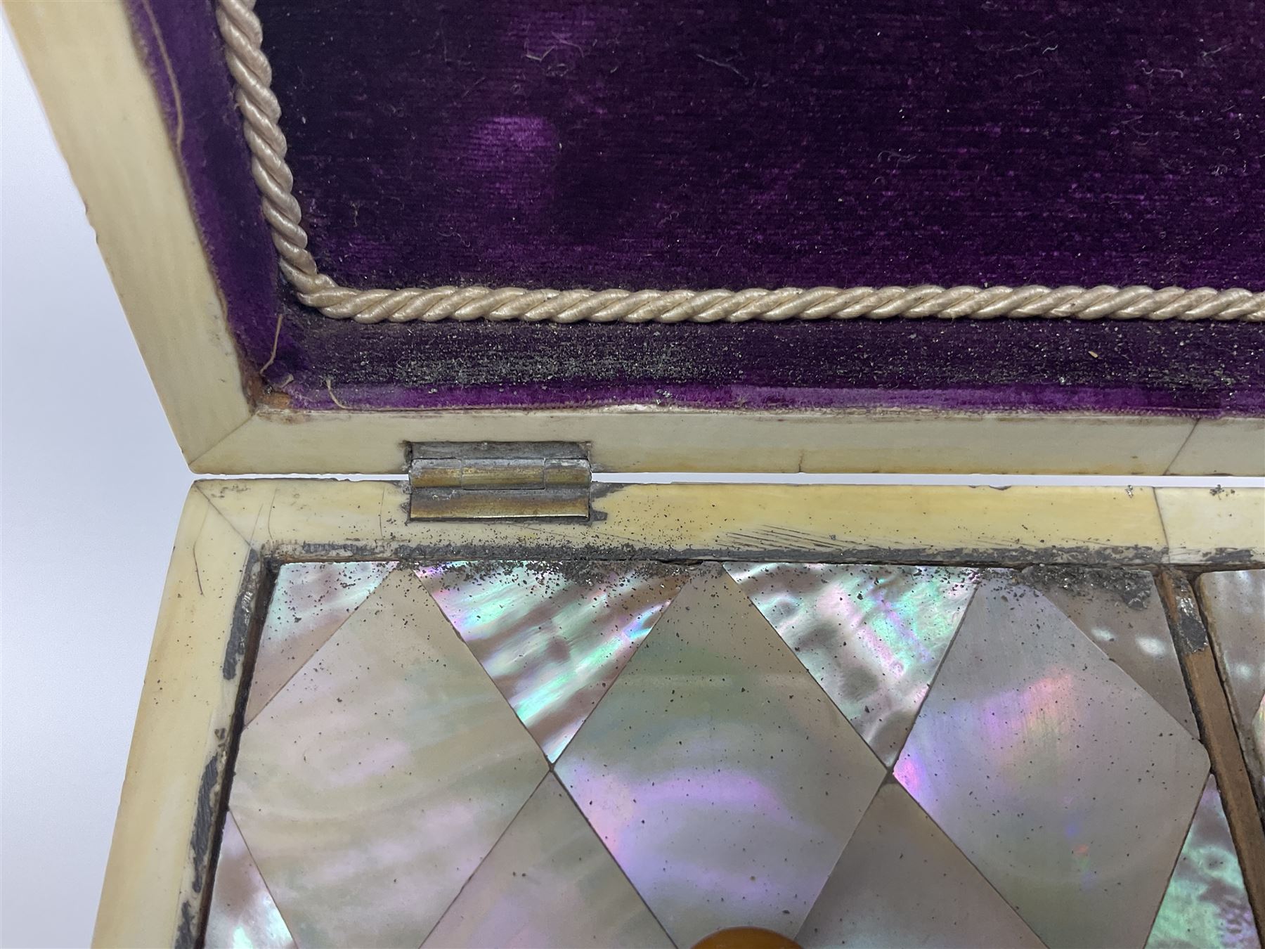 Victorian mother of pearl tea caddy, of rectangular bow-fronted form, the body with floral, bird and geometric engraved mother of pearl panels, white metal shield plaque to the cover inscribed with the initials G.J.A and similar escutcheon, the two division interior with ivory edging and two panelled mother of pearl lids, on four vegetable ivory bun feet L20cm, together with a similar style mother of pearl card case (2) This item has been registered for sale under Section 10 of the APHA Ivory Act