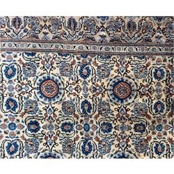 Northwestern Persian Tabriz hand-knotted carpet, the ivory ground with an all-over repeating Herati pattern of stylised palmettes, rosettes and serrated leaves in shades of indigo, terracotta and sky blue, framed by a dark blue border of arabesque vines and scrolling foliage between floral guard stripes, from the region of Tabriz