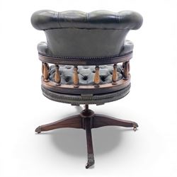 Mid 20th century buttoned green leather office chair, the curved back and arms over a circular frame with turned spindle supports, on a revolving base with four splayed legs and brass castors