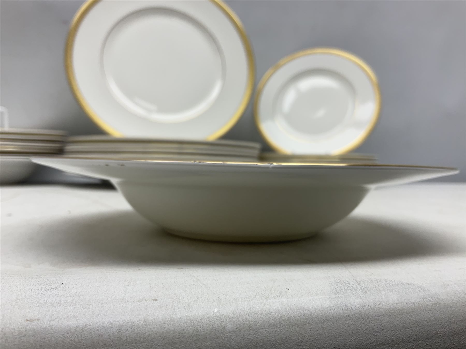 Royal Doulton Royal Gold pattern tea and dinner service for eight, comprising dinner plates, side plates, tea plates, soup bowls, sauce boat and saucer, dessert bowls, coffee cans and saucers, teacups and saucers and two lidded tureens