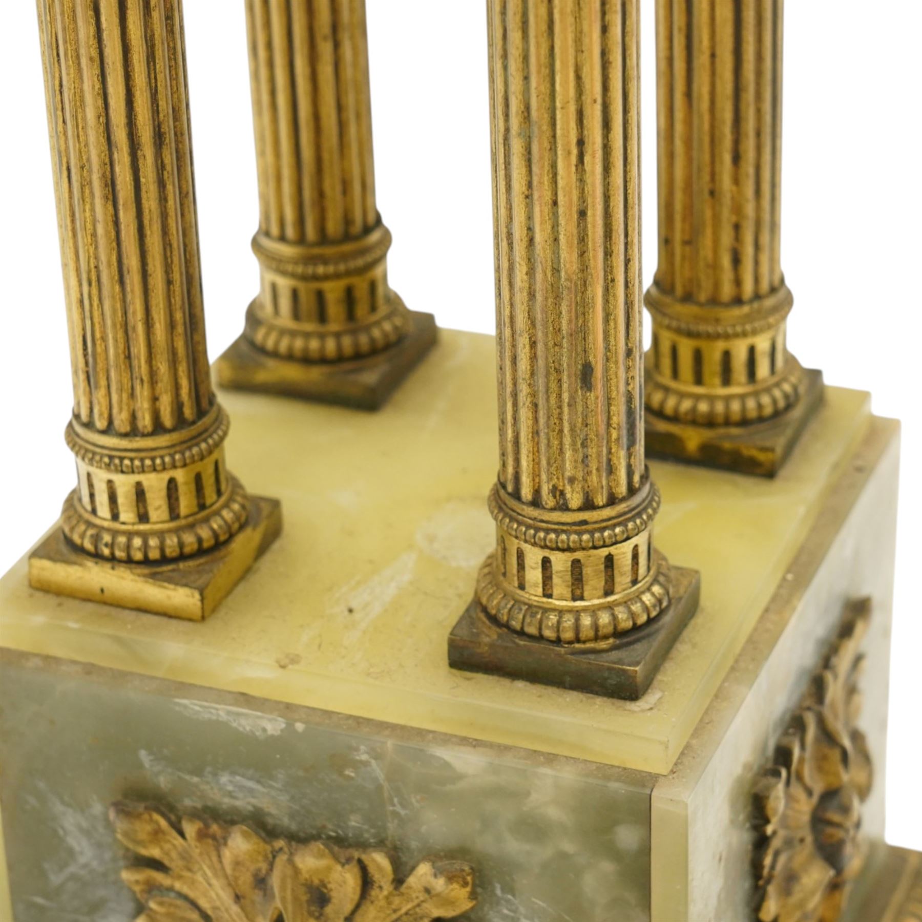 Neoclassical onyx and brass jardinière or plant stand, circular onyx top over an acanthus gilt frieze, supported by for fluted composite columns, square plinth with applied rosette mounts and stepped base, raised on scroll feet  