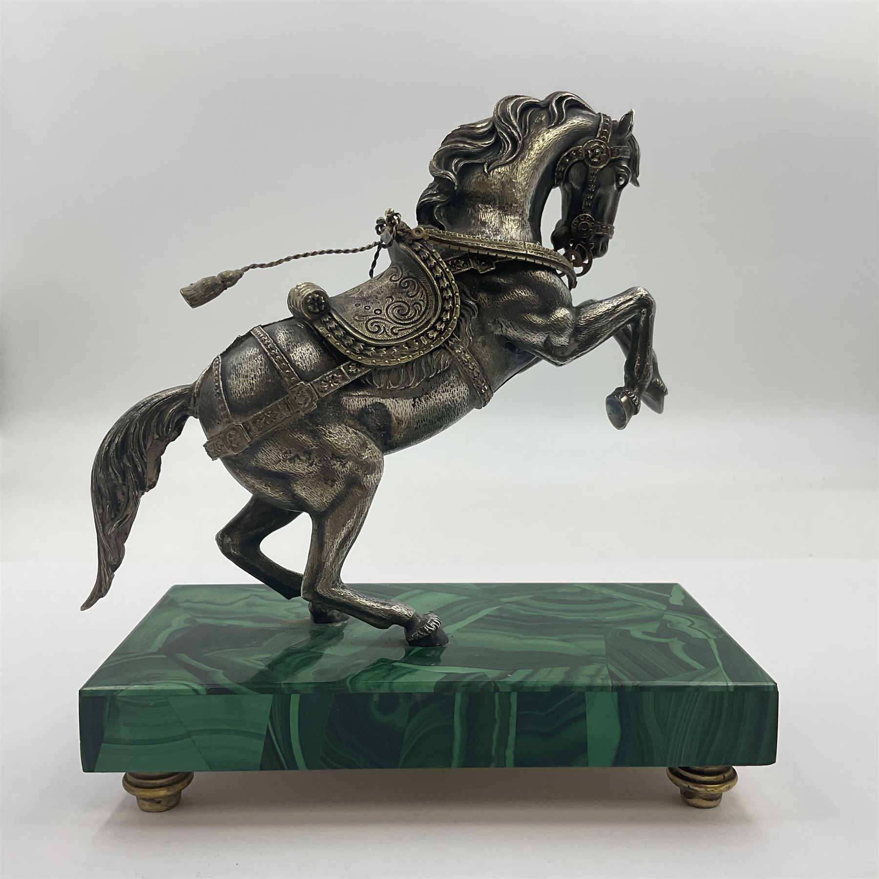 Modern silver model of a rearing horse, with ornate parcel gilt saddle and bridle, mounted upon a rectangular base, decorated with malachite panels to each side and upon four gilt bun feet, horse stamped 925, overall H14.5cm