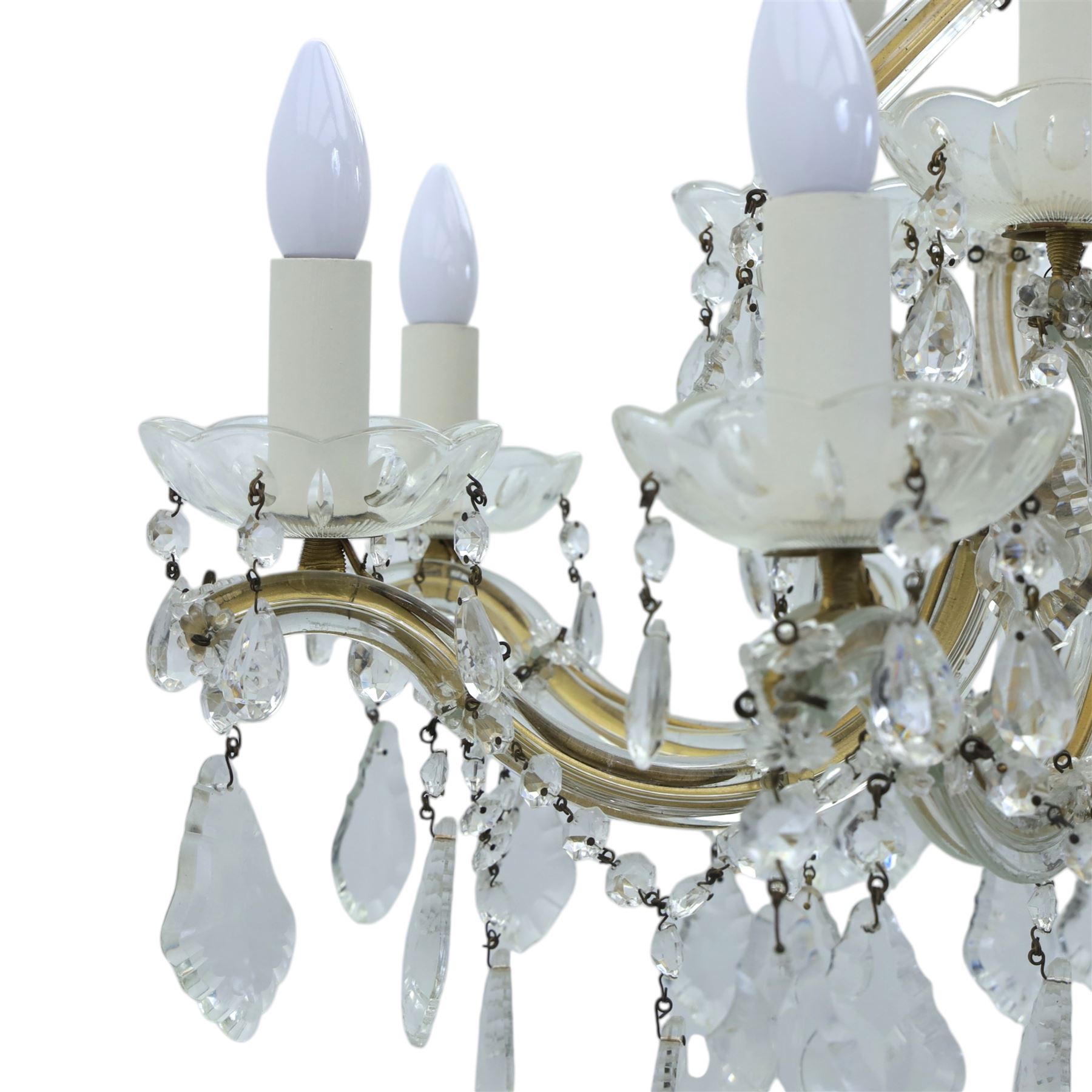 20th century Maria Theresa style twelve branch chandelier, gilt metal frame with scrolling arms clad in moulded glass, the central baluster stem issuing twelve candle sconces with glass drip pans, hung with faceted pendants and swags of cut glass beads 