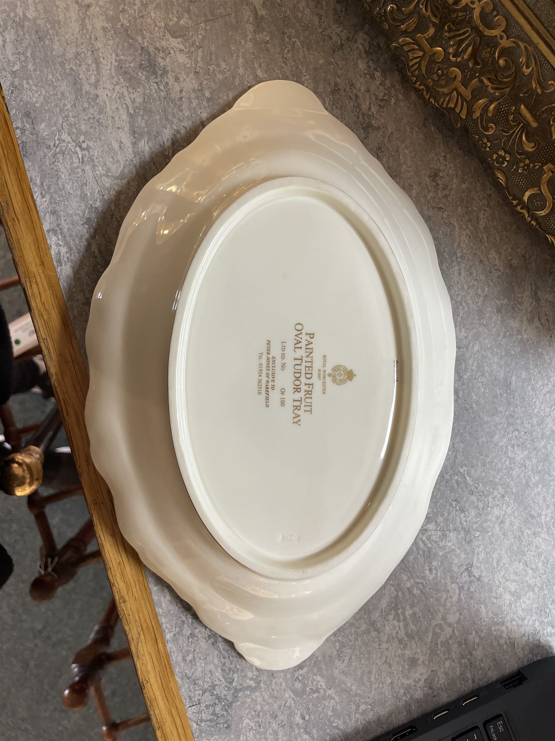 Late 20th century Royal Worcester dish, of oval form with gilt shaped rim and twin shell handles, hand painted by Jason Bowman with still life of fruit upon mossy ground, signed J Bowman, wit marks beneath, with makers fitted card box


