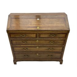 Early 19th century oak and mahogany banded converted bureau chest, the sloped top lifts from the bottom to reveal fitted compartment, over two short false drawers and three long drawers, on bracket feet
