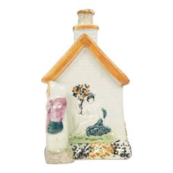 19th Century Staffordshire pearlware Prattware type money box, modelled as a houe with two figures to the front corners, H13cm