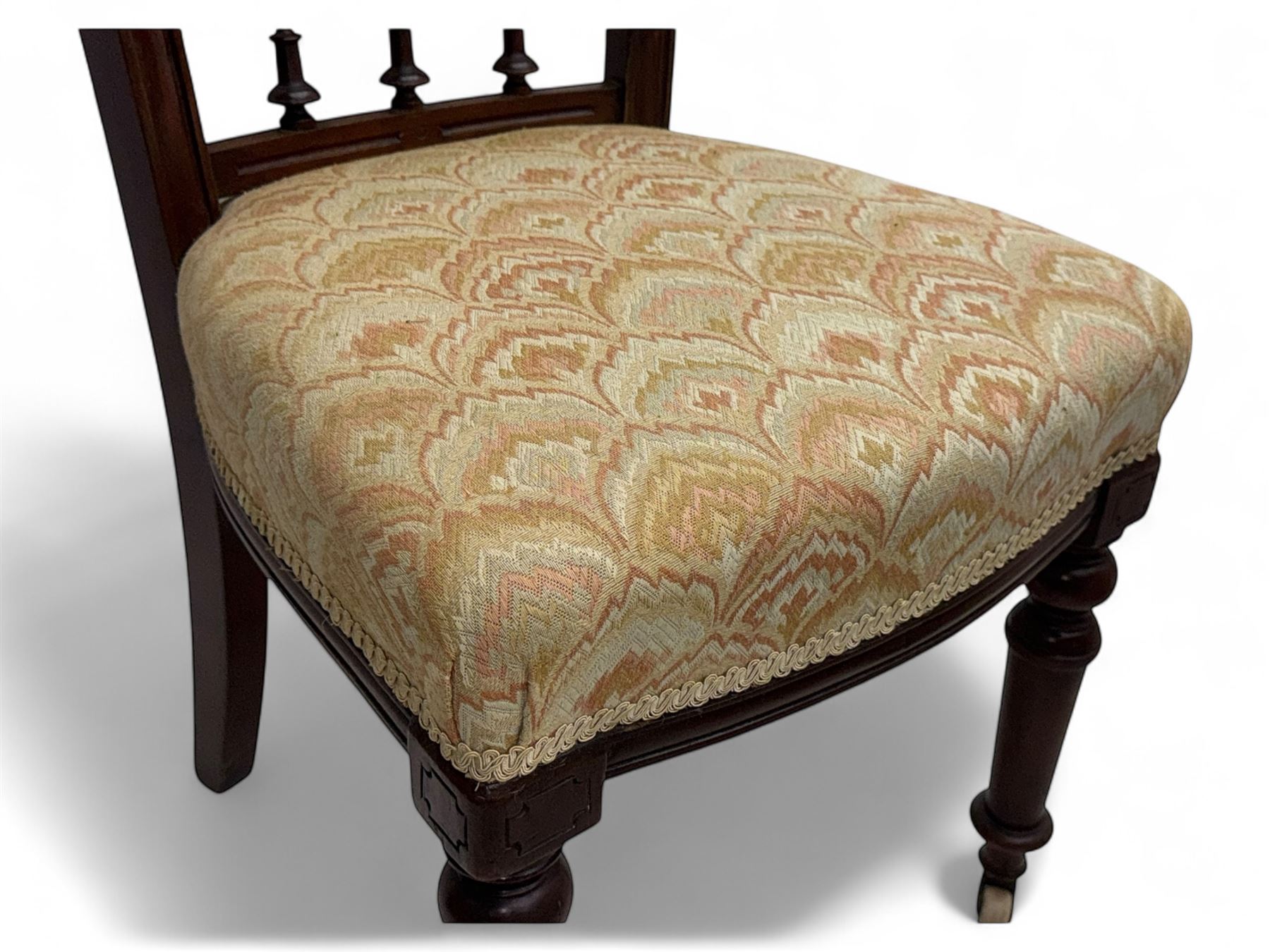 Victorian mahogany centre table, circular top above turned pedestal, terminating on three cabriole legs with scroll feet on porcelain castors, and six scroll carved upholstered dining chairs, with cushion and spindle turned backs, centre table  118x74cm, dining chairs 89x46x50cm