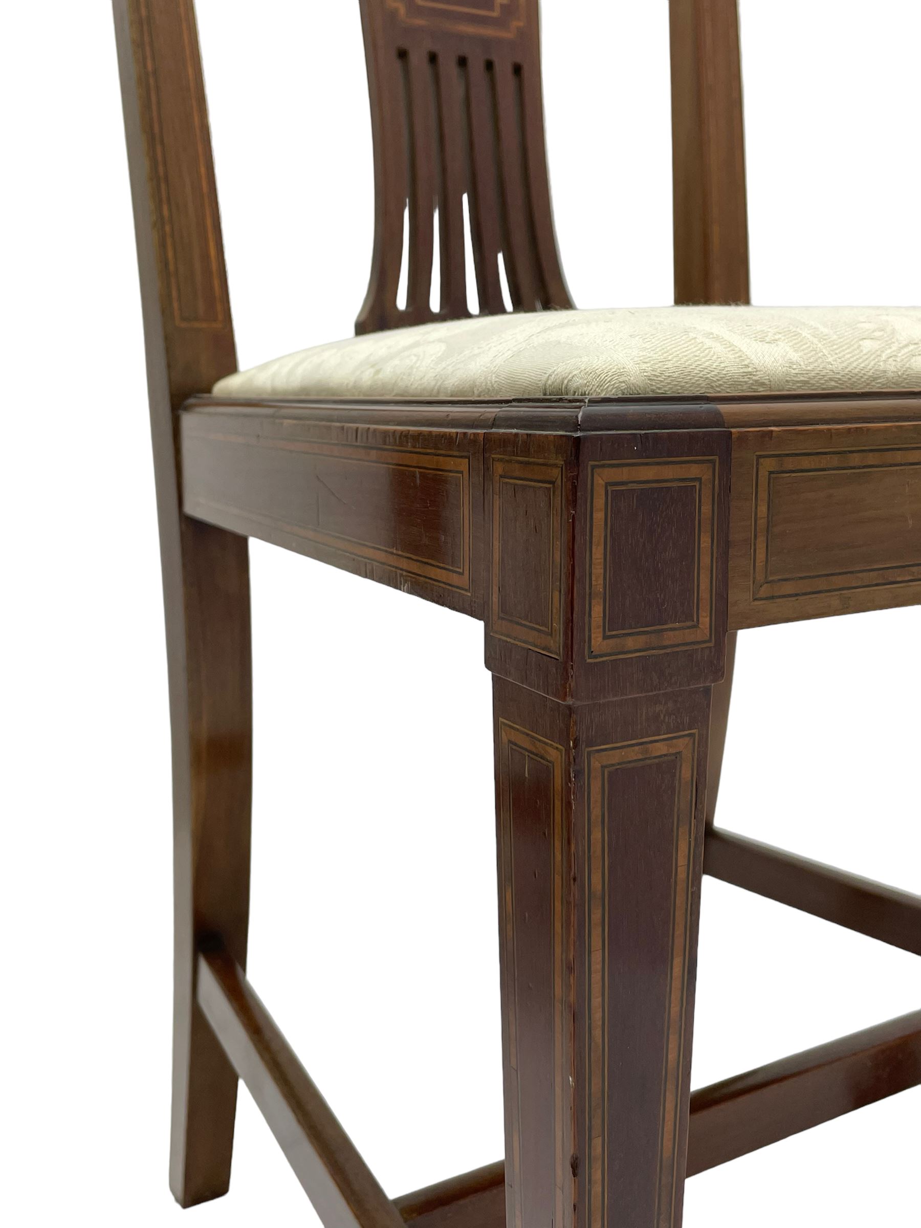 Set twelve (4+8) Edwardian inlaid mahogany dining chairs, cresting rail with satinwood banding, pierced splat backs with central inlay, drop-in seats upholstered in foliate patterned ivory fabric, raised on square tapering supports terminating in spade feet